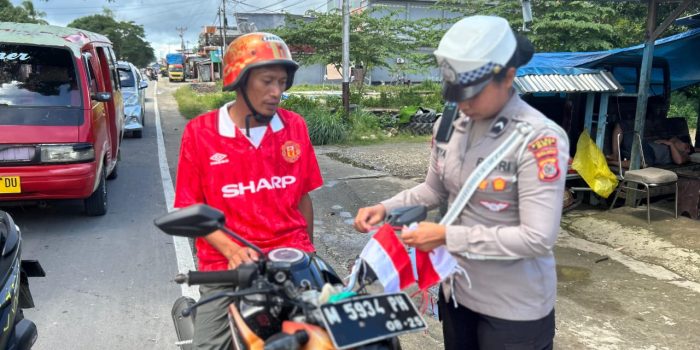 Polres Seram Bagian Timur Bagikan Bendera Merah Putih kepada Pengendara di Kota Bula