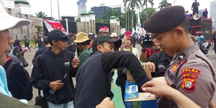 Aksi Simpatik, Polisi Bagikan Air Mineral dan Roti kepada Buruh di Depan DPR/MPR
